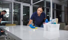 istockphoto-2164734998-612x612 Cleaner, woman and cleaning table office for fumigation, spray disinfect and safety suit from disease risk in building. Maintenance, person and chemical liquid for pest control, health and hygiene